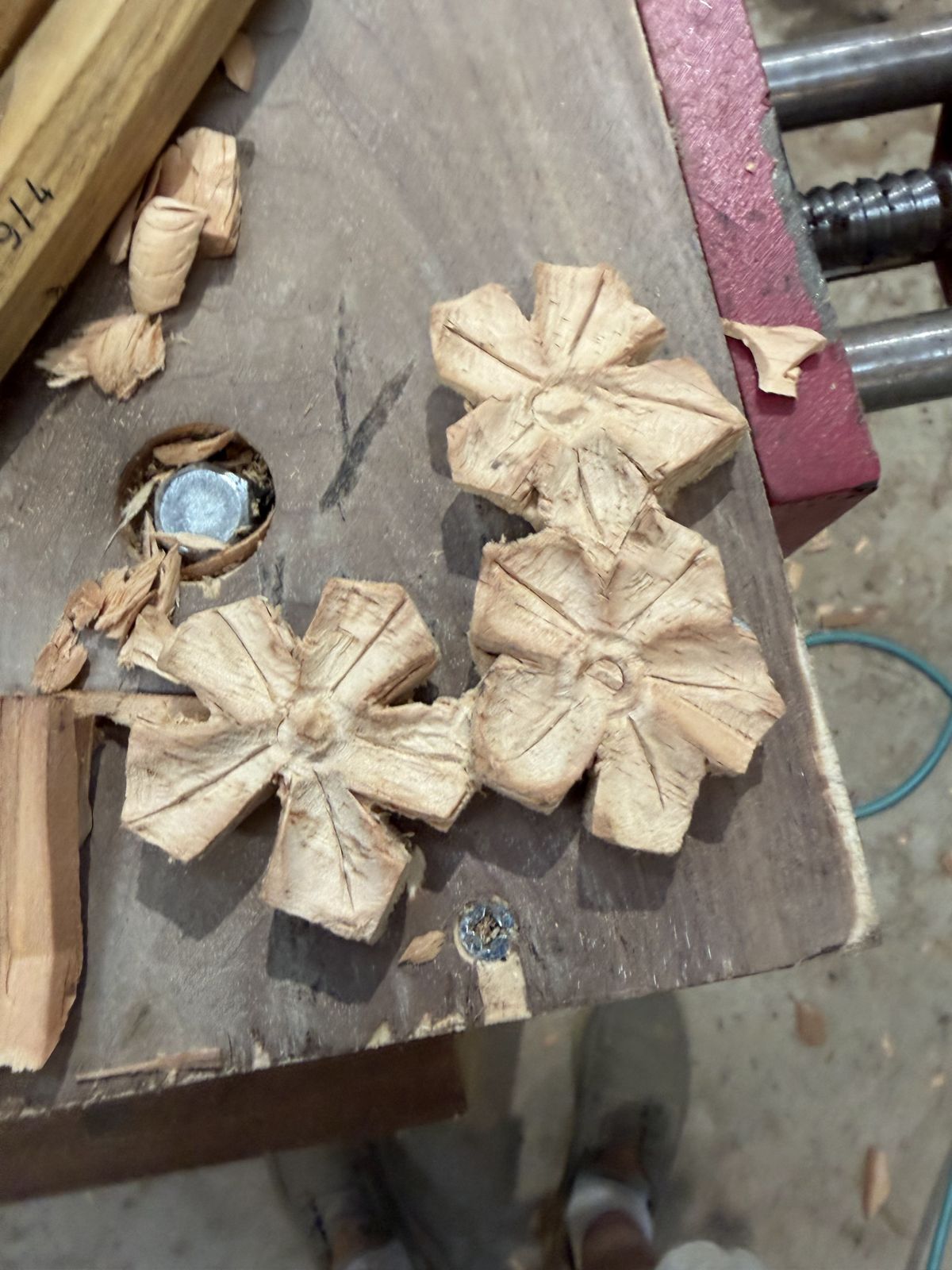 Hand-carved wooden rosettes on the bench with wood chips