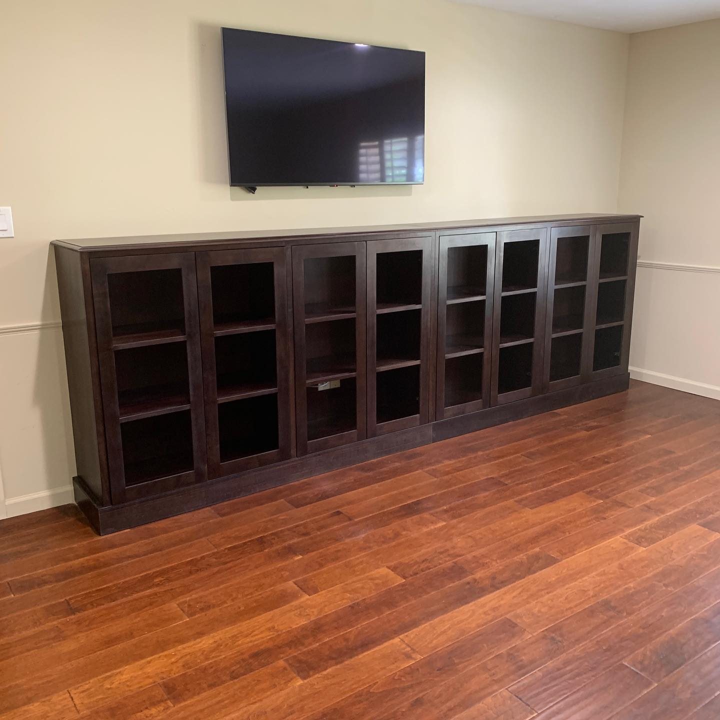 Long low run of dark-stained glass-front display cabinets