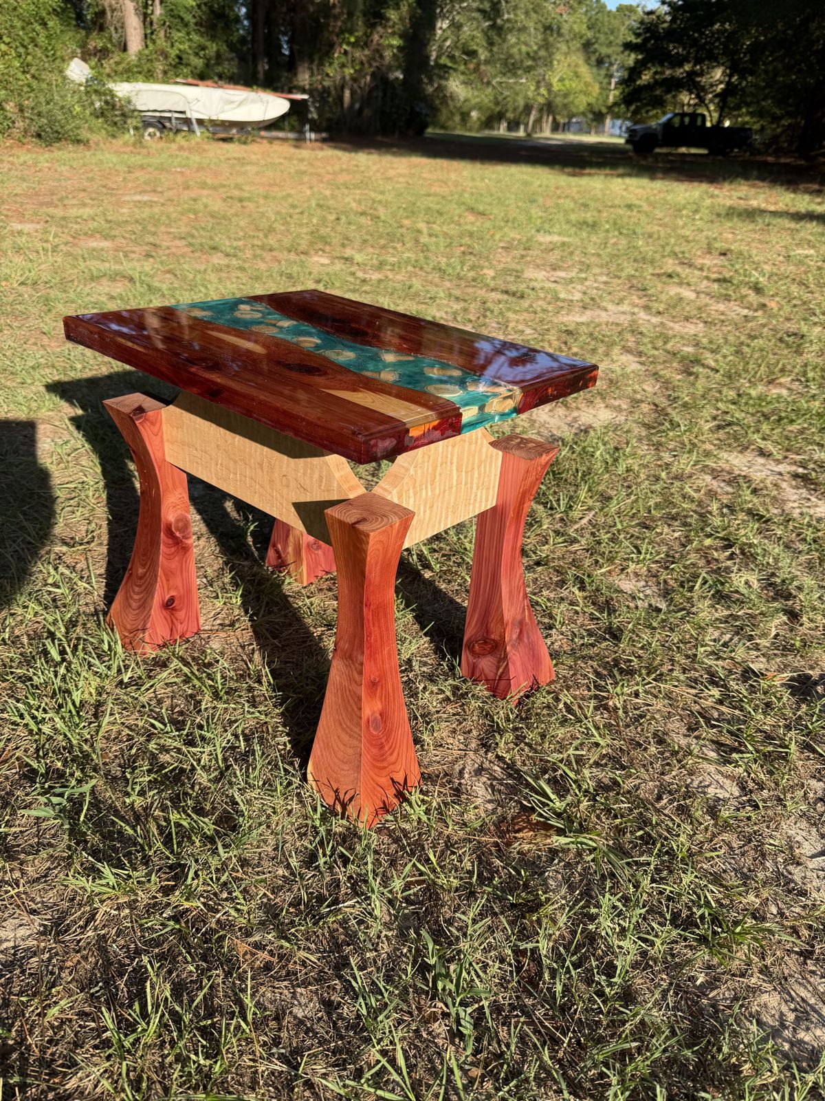 End table with turquoise epoxy inlay and flared legs, photographed outdoors