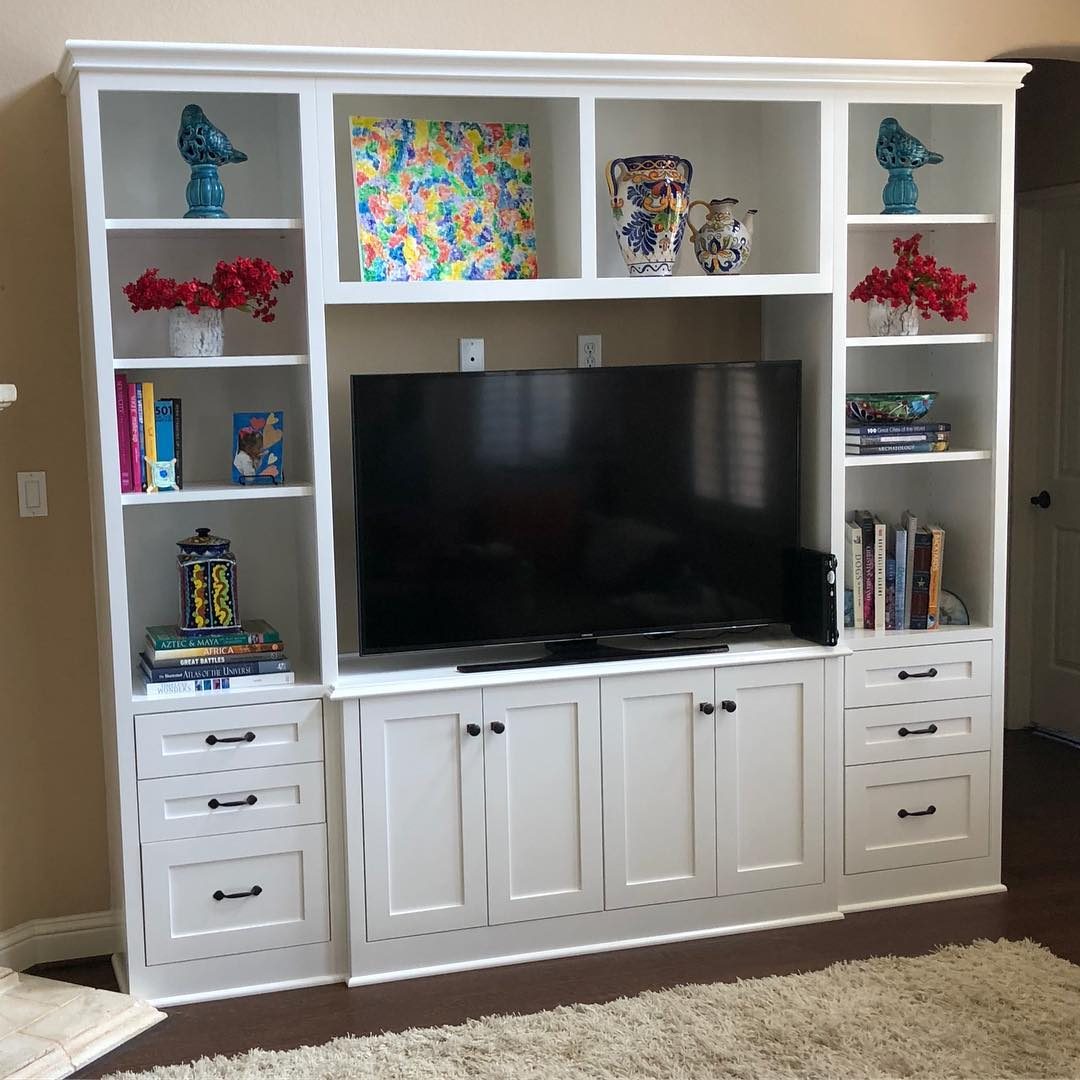 White painted entertainment center with open shelves and drawers