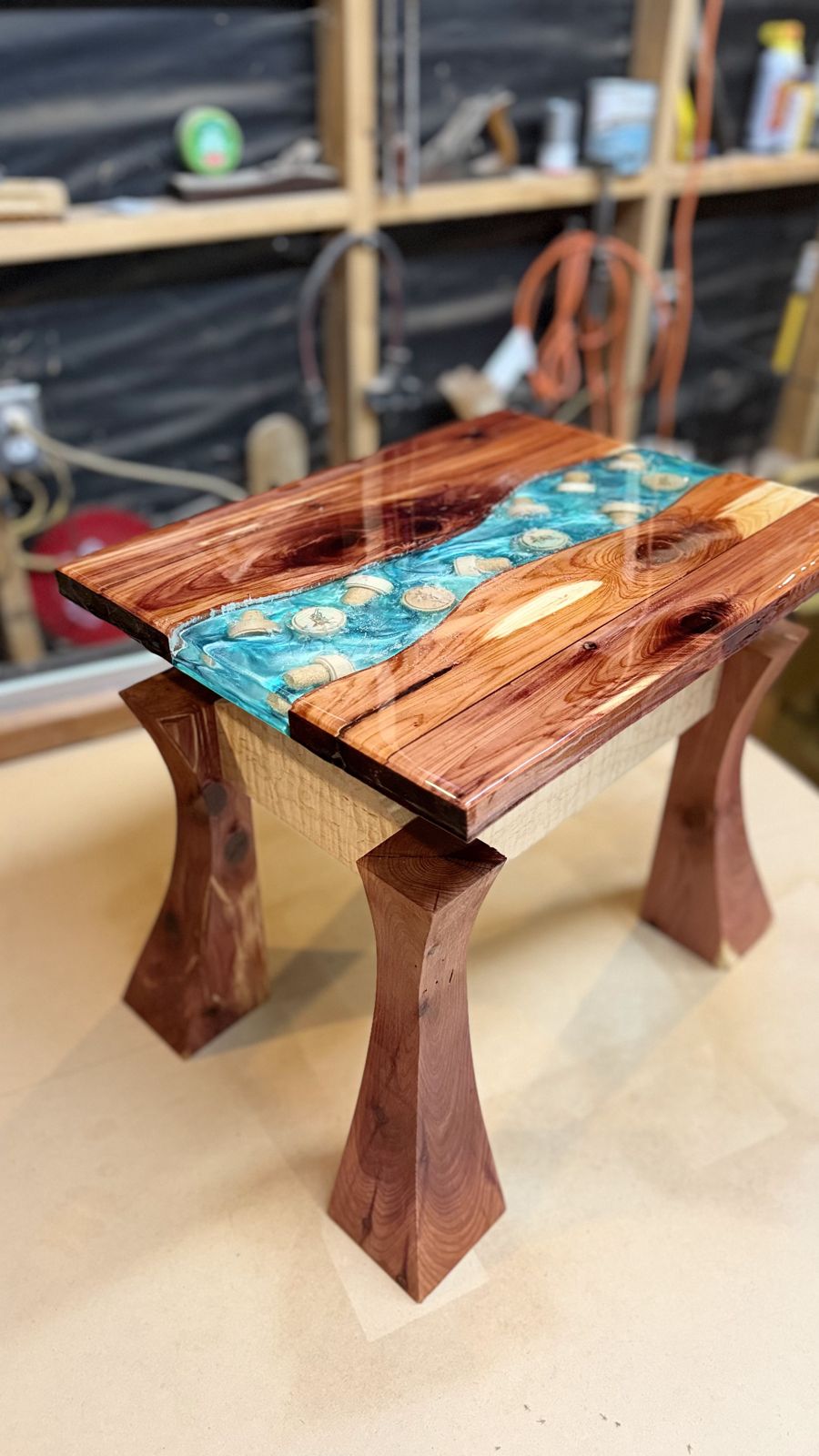 Finished end table with a glossy wood top, a turquoise epoxy river and four hand-shaped flared legs
