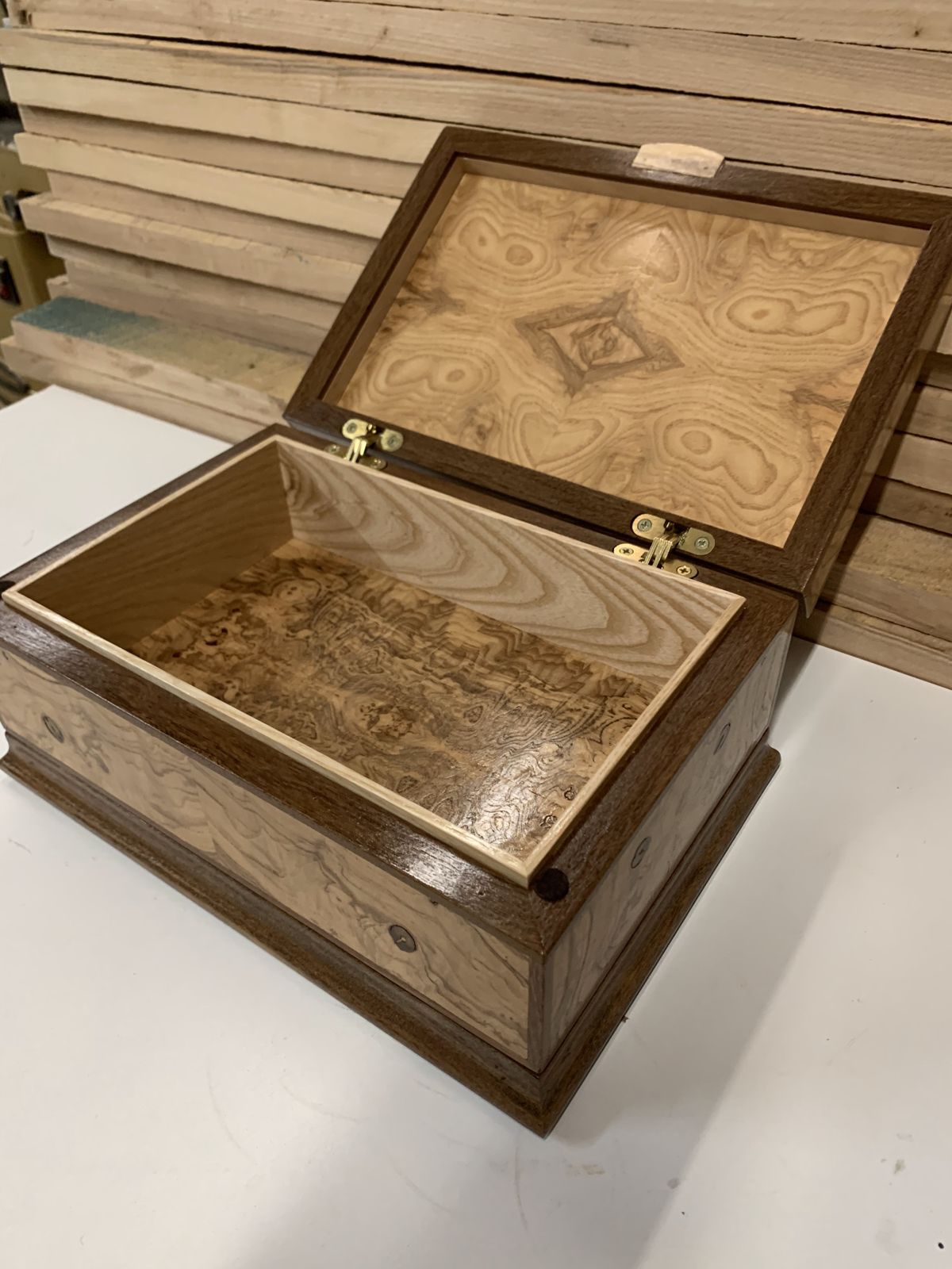 Open keepsake box with a book-matched burl lid and a figured interior