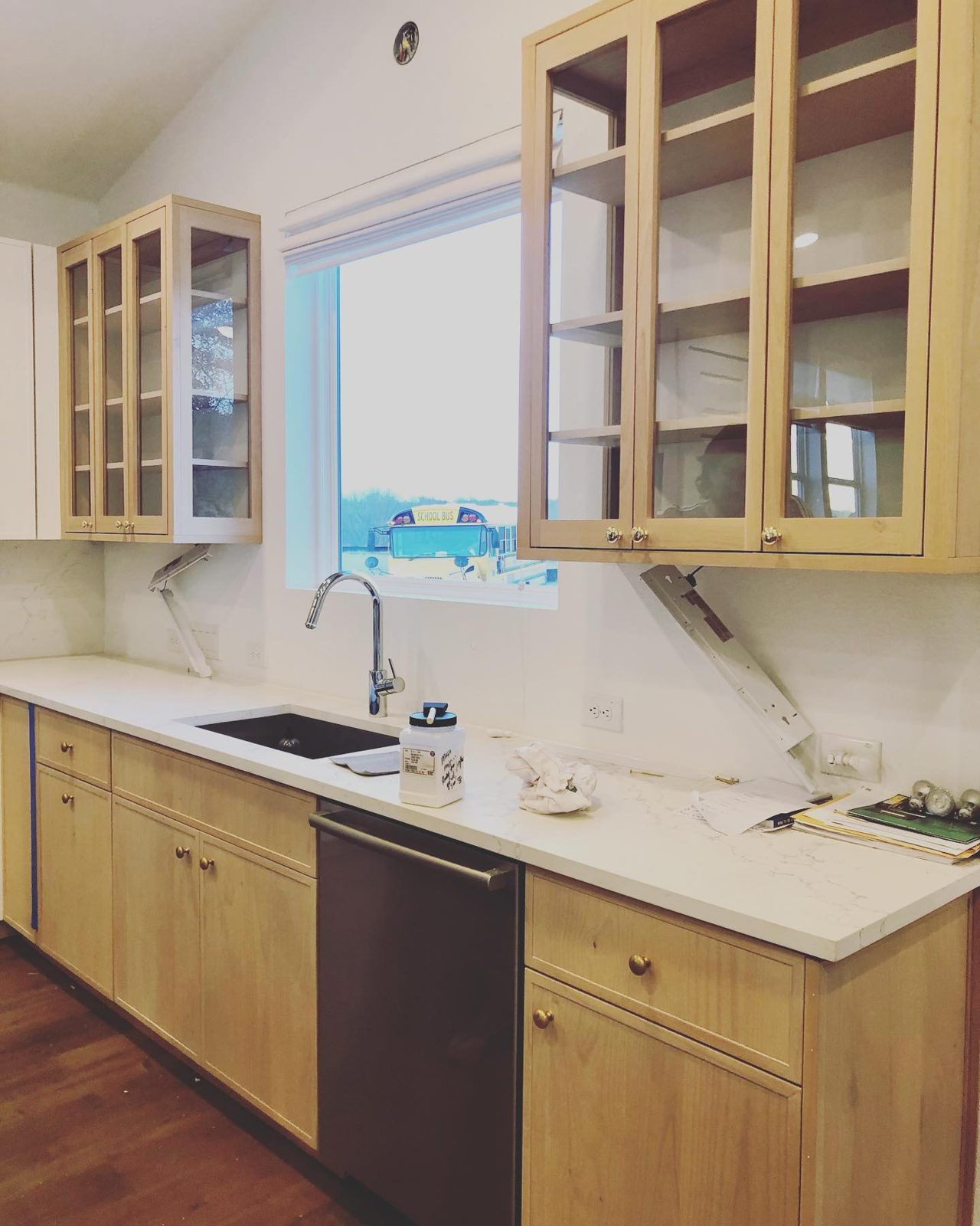 Kitchen with white-washed alder cabinets and glass-front upper doors