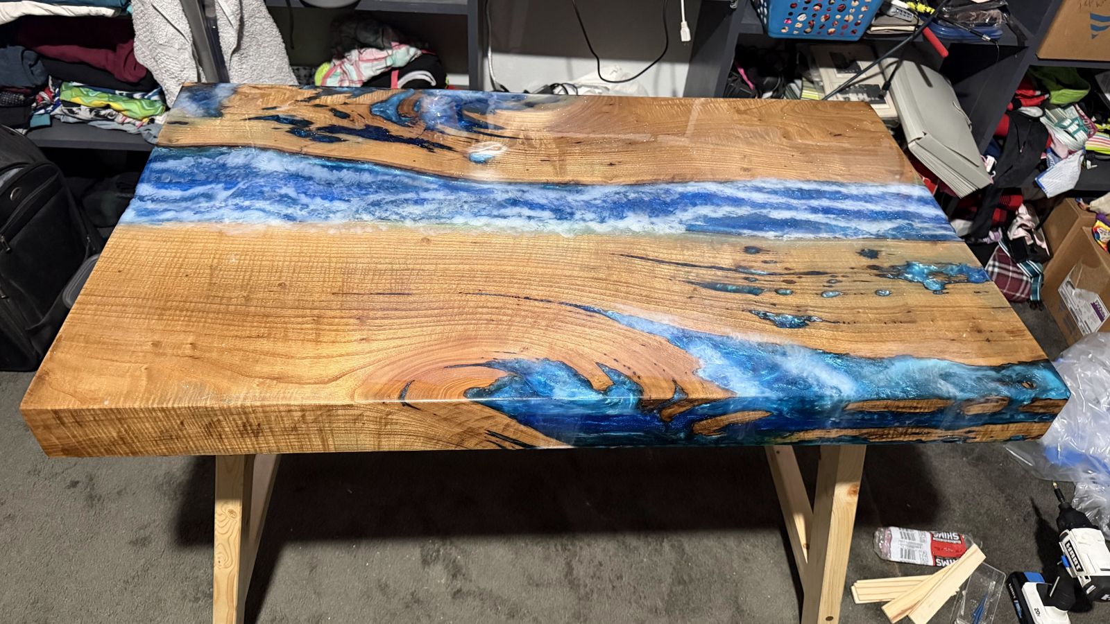 Live-edge slab table with a deep blue epoxy river running its length