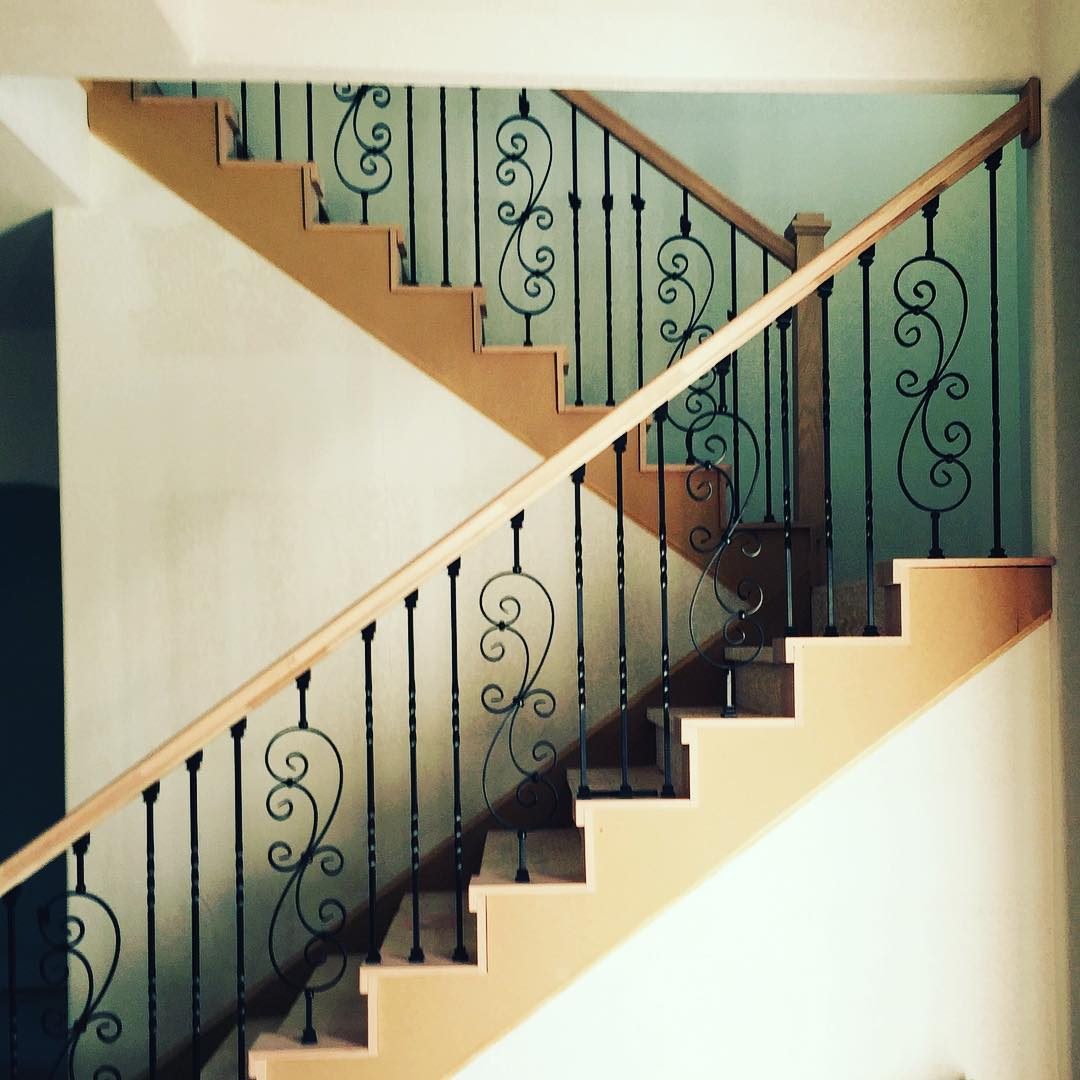 Staircase with wood treads and rail and scrolled iron balusters